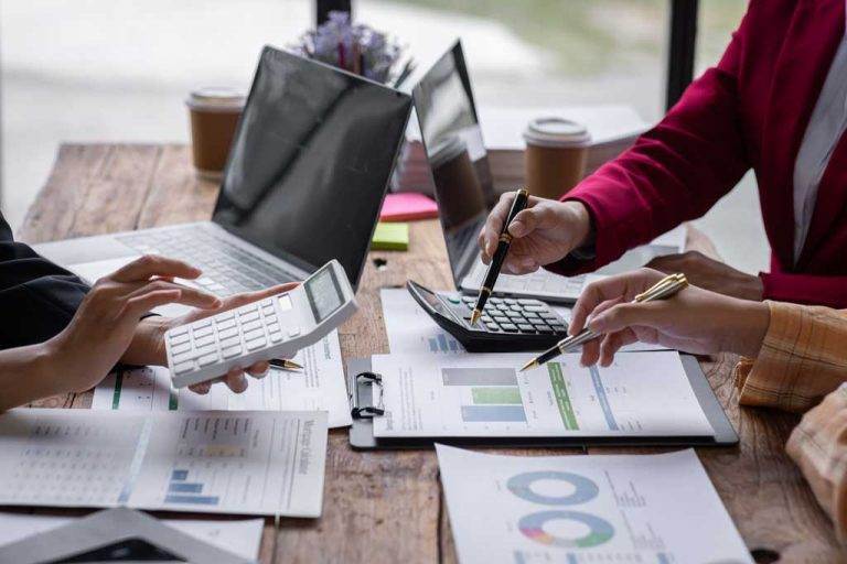 group of confident business people point to graphs